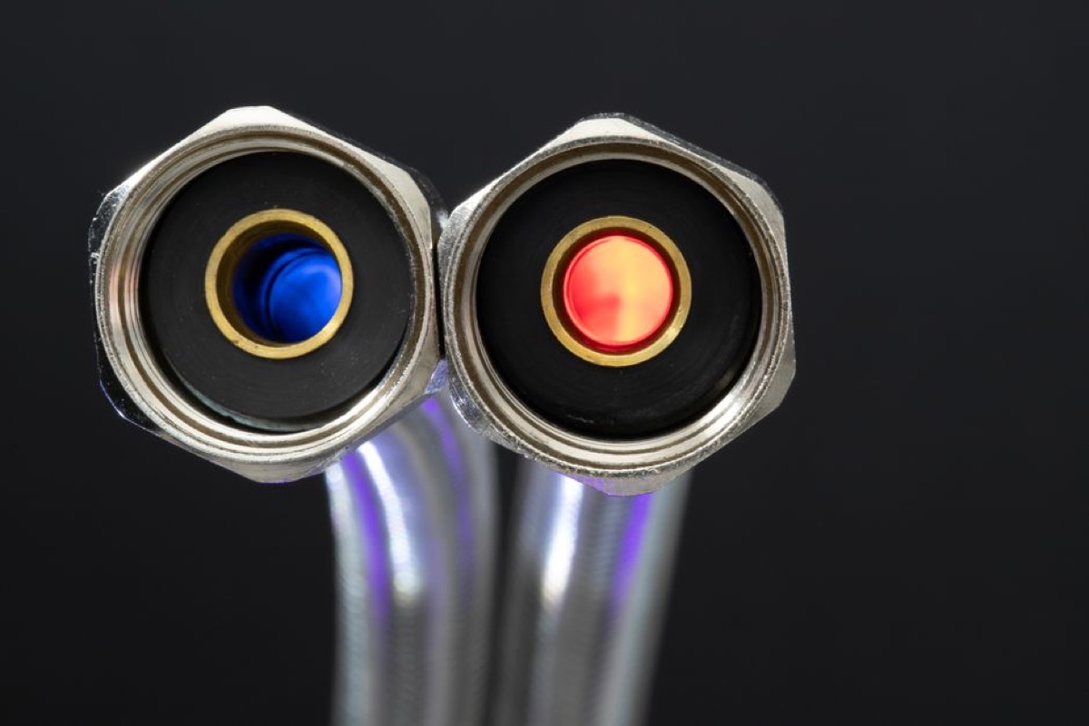 Close-up of braided hot and cold water supply hoses with color-coded red and blue connectors