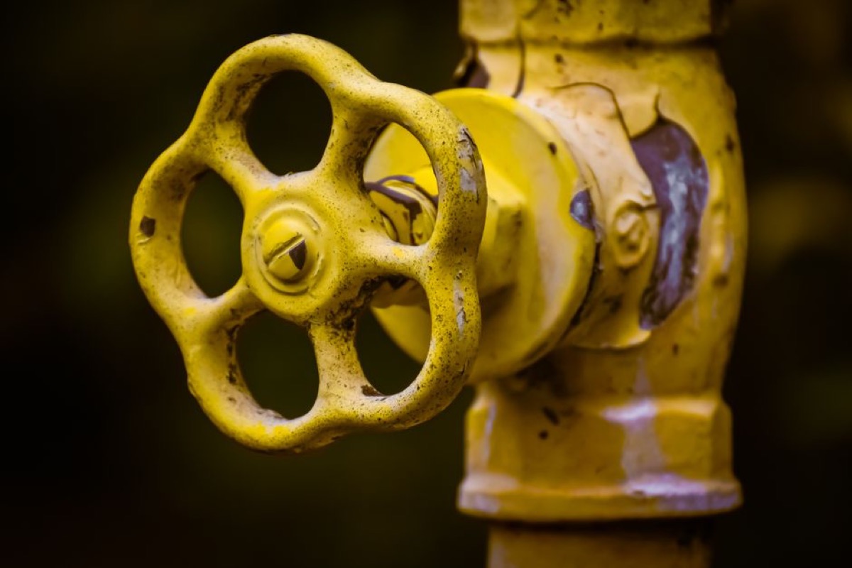 Yellow gas shutoff valve on a residential gas line, showing the type of valve used in tankless water heater installations