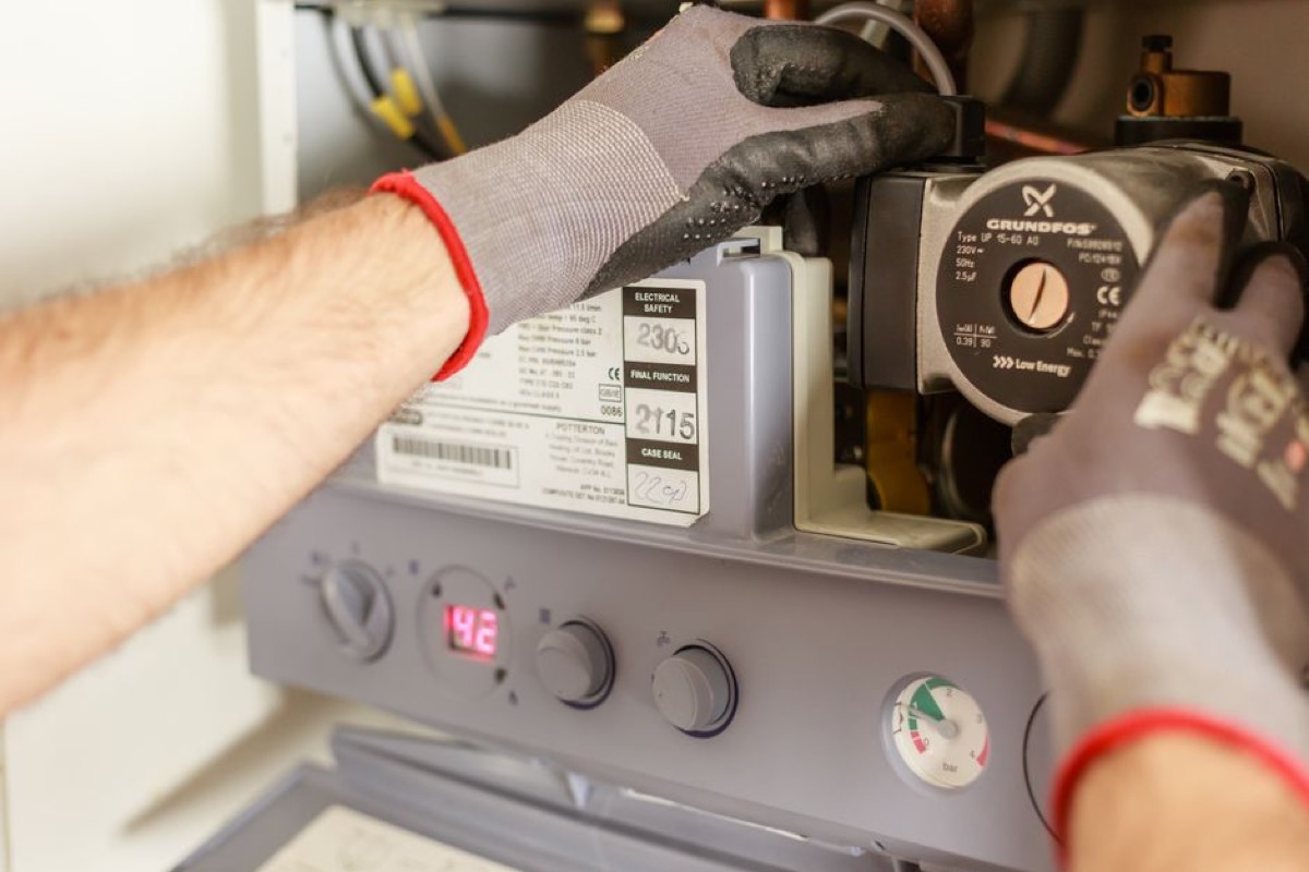 HVAC technician installing tankless water heater equipment
