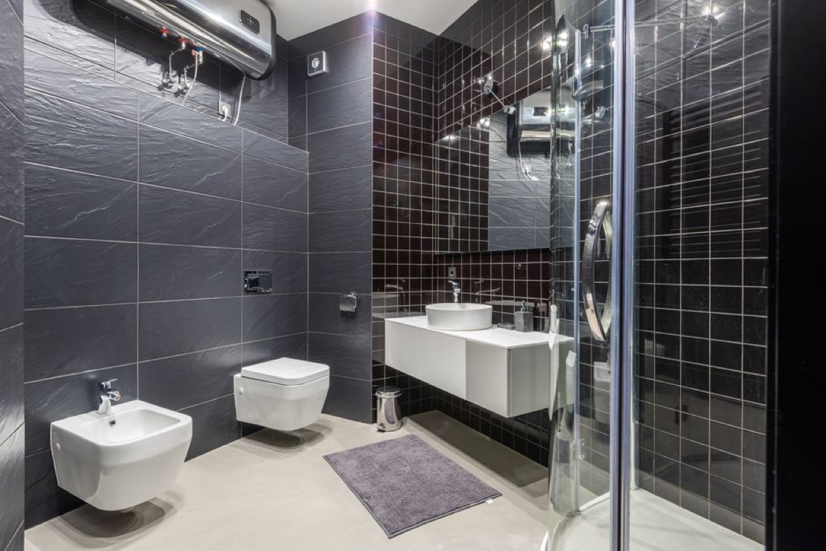 Modern bathroom with wall-mounted heating unit and shower enclosure showing hot water delivery point