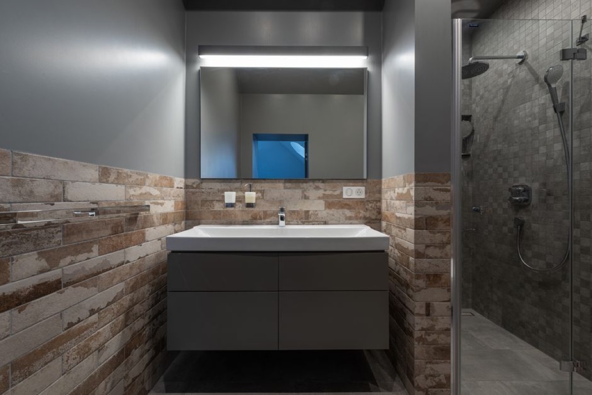 Modern glass shower enclosure with rain showerhead - the end point where tankless water heater performance is measured