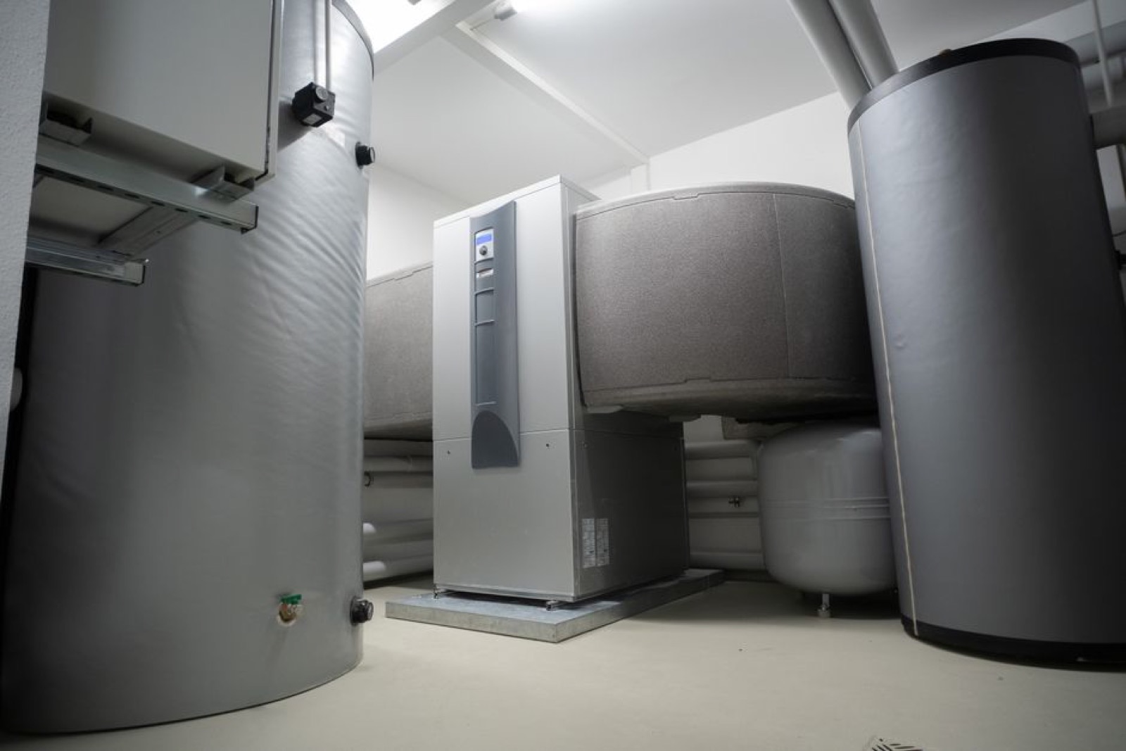 Heat pump water heating system with buffer tanks in modern home mechanical room