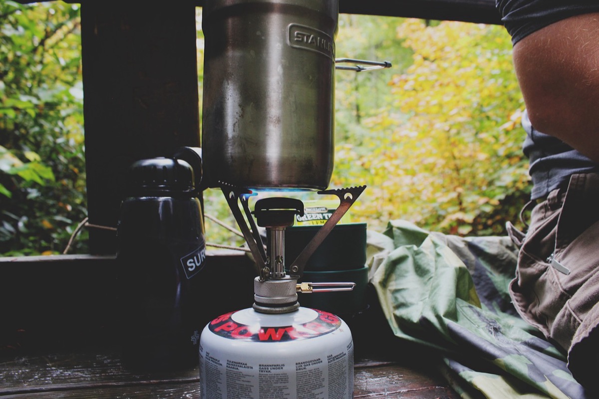 Portable propane camp stove setup outdoors showing typical propane tank and regulator connection used with camping gas appliances