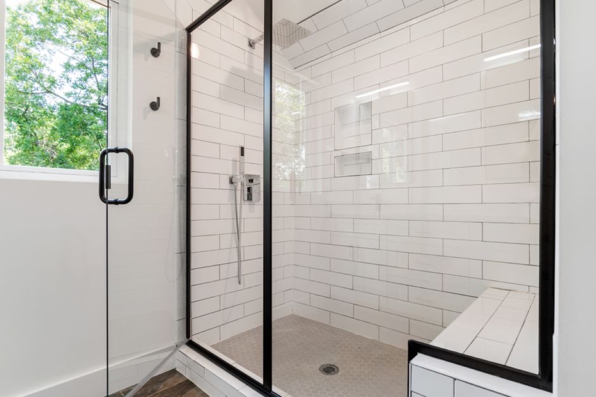 Modern sleek shower with glass panels and clean tile, representing a multi-fixture shower setup that benefits from a thermostatic diverter valve