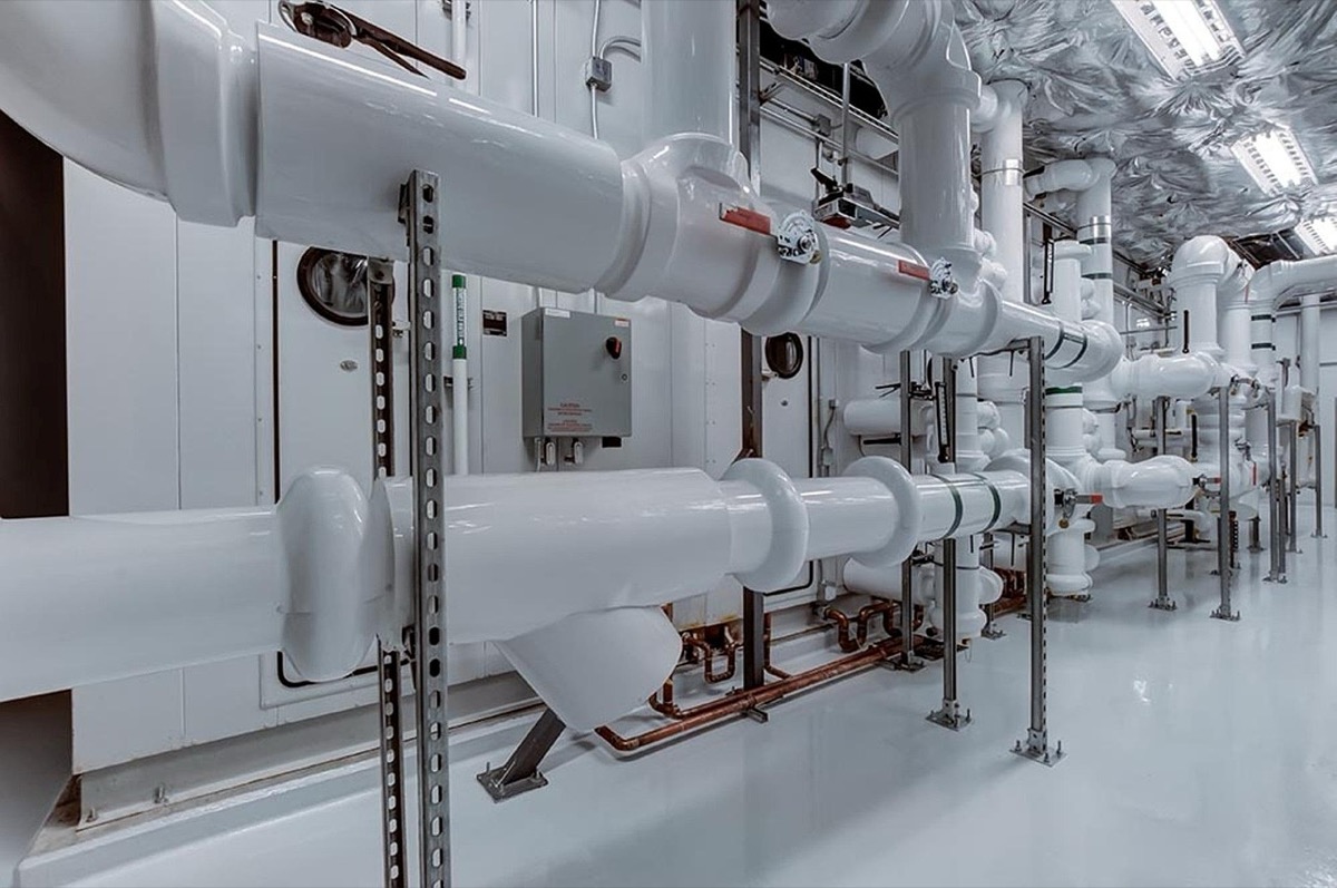 Heavily insulated white pipes in a mechanical utility room showing proper freeze protection insulation methods